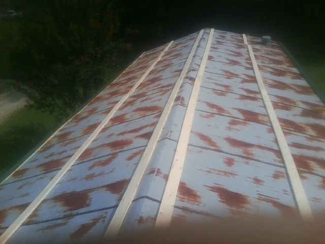 Rusted metal roof panels with new wood purlins before replacement — Storm Damage Roof Repair in Camp Lejeune by Roofing Brothers