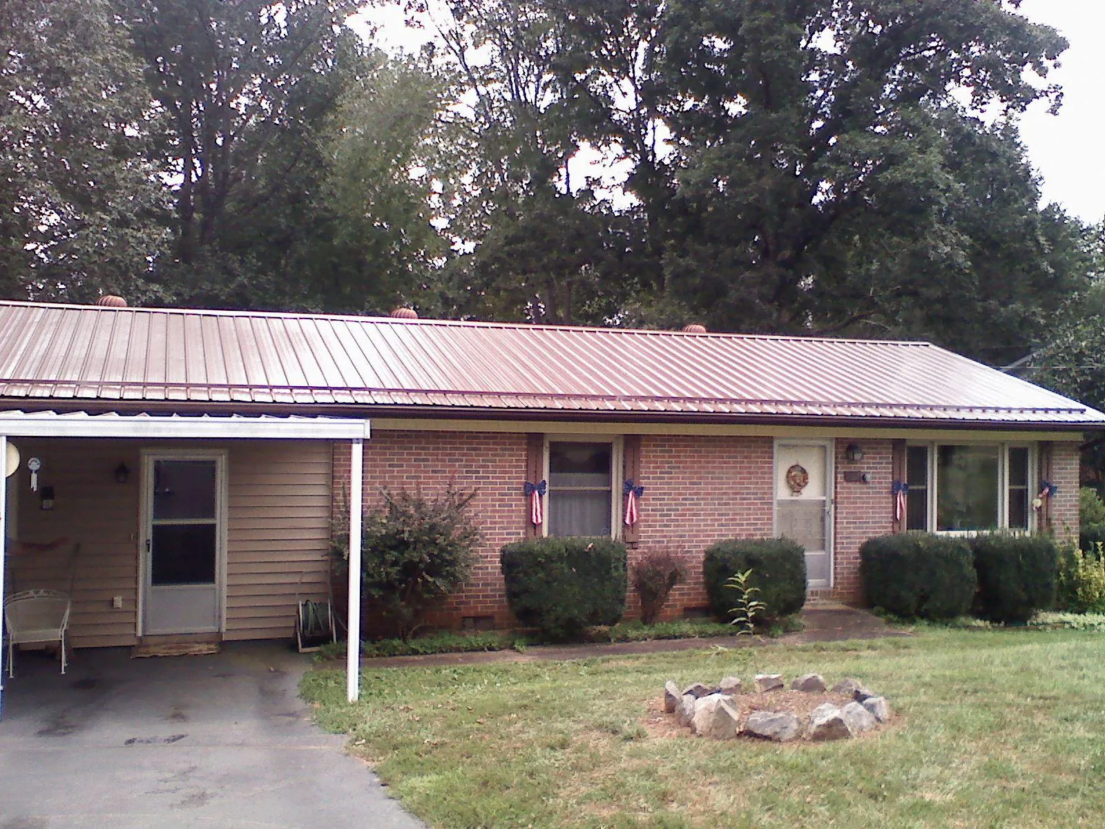 Bronze metal roof and carport on a brick ranch home — Roof Repair work by our crew in Camp Lejeune