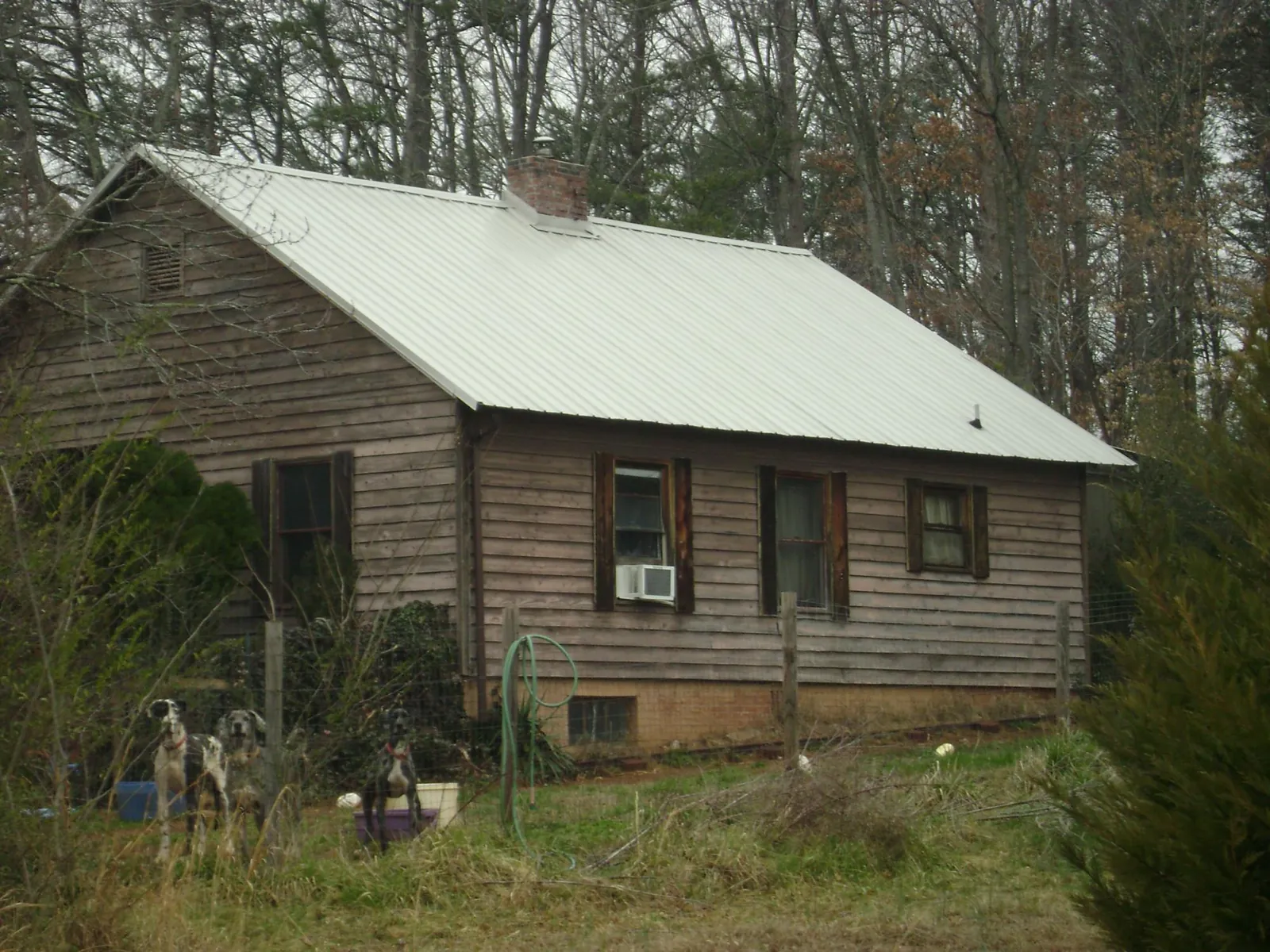 White metal roof on an old wood sided farmhouse, from a Metal Roof Installation job in Camp Lejeune
